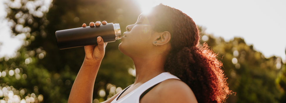 Exercising person drinking water outdoors